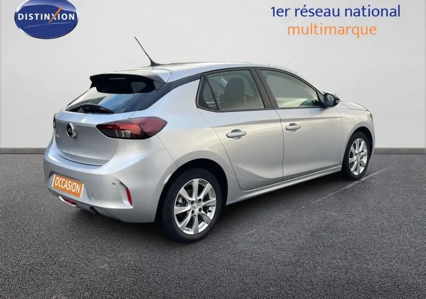 Vue 3/4 arrière droite d'une Opel Corsa gris kristall metal 2022 à cinq portes avec jantes alliage et toit noir.