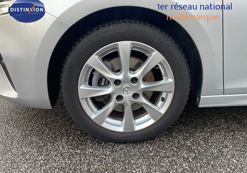 Gros plan sur la roue avant gauche d'une Opel Corsa gris kristall metal avec jante alliage 16 pouces.