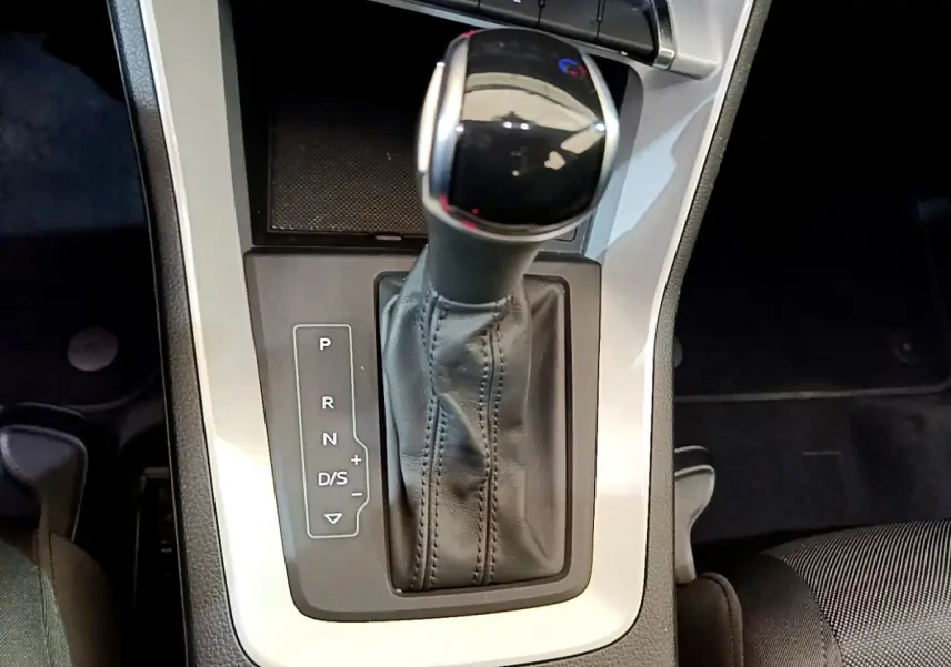 Le levier de vitesses automatique noir et chrome de l'Audi Q3 35 TDI 2021 vu de dessus, entouré de console grise.