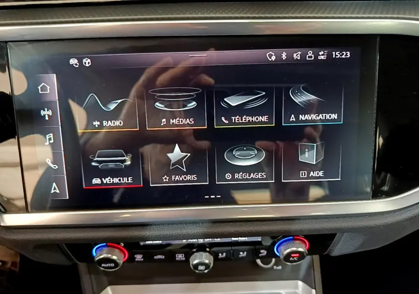 Écran tactile central de l'Audi Q3 35 TDI 2021 affichant le menu multimédia et navigation, vue intérieure frontale.