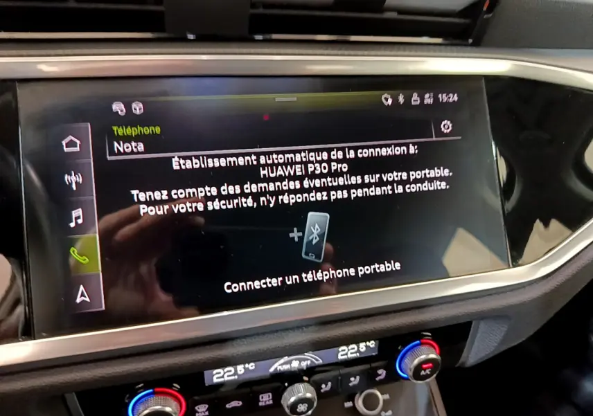 Écran tactile central affichant la connexion Bluetooth dans l'Audi Q3 noir, vue intérieure du tableau de bord.