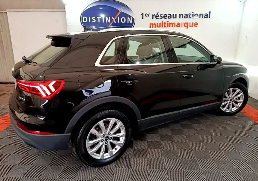 Audi Q3 35 TDI noir vue 3/4 arrière côté gauche, avec feux arrière LED et jantes alliage visibles.