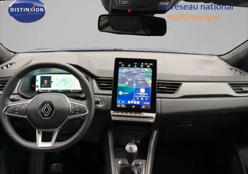 Vue intérieure frontale du tableau de bord du Renault Captur 2025, avec écran tactile vertical et volant multifonction noir.