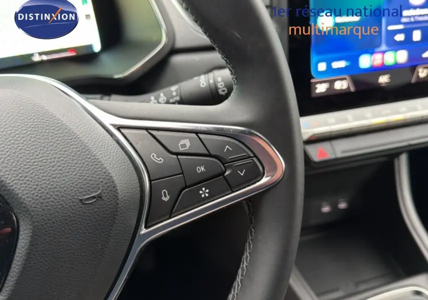 Gros plan sur le volant cuir noir du Renault Captur 2025 avec commandes multifonctions et tableau de bord numérique.