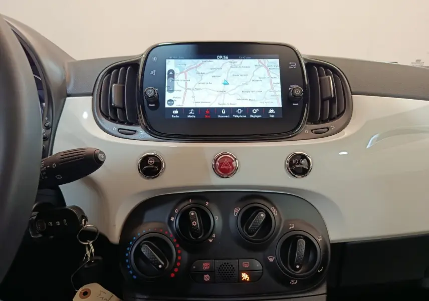 Tableau de bord blanc de Fiat 500 Hybrid 2022 avec écran tactile central affichant une carte de navigation.