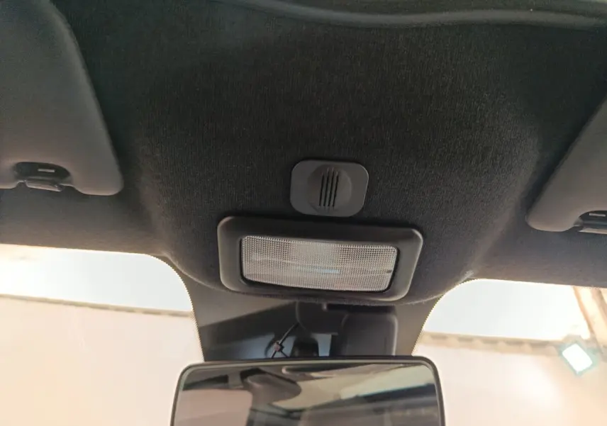 Vue intérieure centrée sur le plafonnier et le rétroviseur d'une Fiat 500 blanche, version Hybrid Dolcevita 2022.