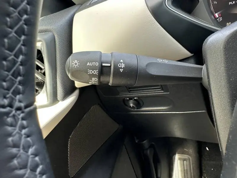 Gros plan sur la manette de commandes d’éclairage à gauche du volant dans l’habitacle clair du DS3 2024 Cristal Pearl.