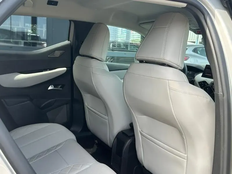 Vue intérieure arrière du DS3 2024 avec sièges en cuir clair et panneaux de porte bicolores, ambiance lumineuse naturelle.