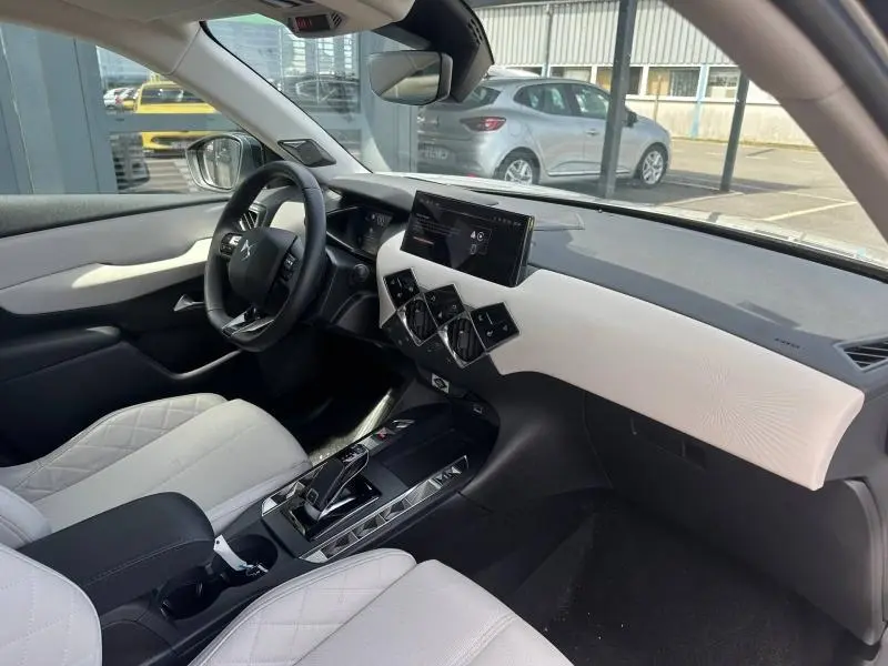 Vue intérieure côté conducteur du DS3 2024, avec sellerie claire, tableau de bord blanc et écran tactile central.