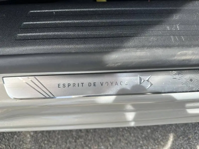Gros plan sur la plaque de seuil de porte "Esprit de Voyage" du DS3 2024, finition Cristal Pearl avec toit noir.