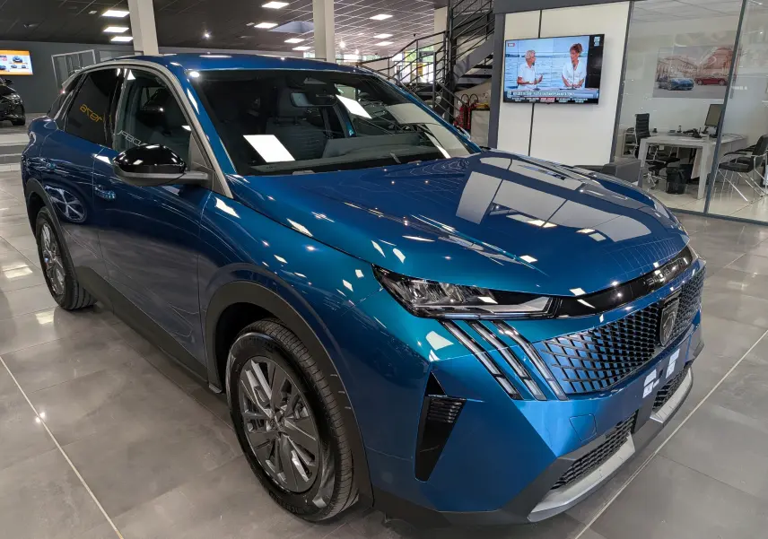 Vue 3/4 avant droite du Peugeot 3008 Hybrid 145 ch bleu Obsession, avec calandre distinctive et phares LED fins.