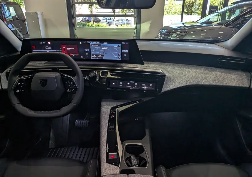 Vue intérieure du tableau de bord du Peugeot 3008 Hybrid 145 ch, avec écran numérique panoramique et finition tissu gris.