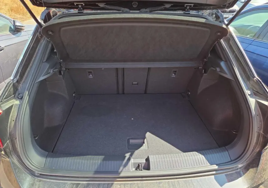 Coffre ouvert du Volkswagen T-Roc noir métal 2025, vue arrière montrant l’espace de chargement vide et propre.