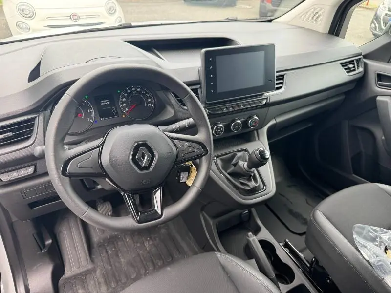 Vue intérieure avant du Renault Kangoo Van 2024, tableau de bord noir avec volant multifonction et écran tactile central.