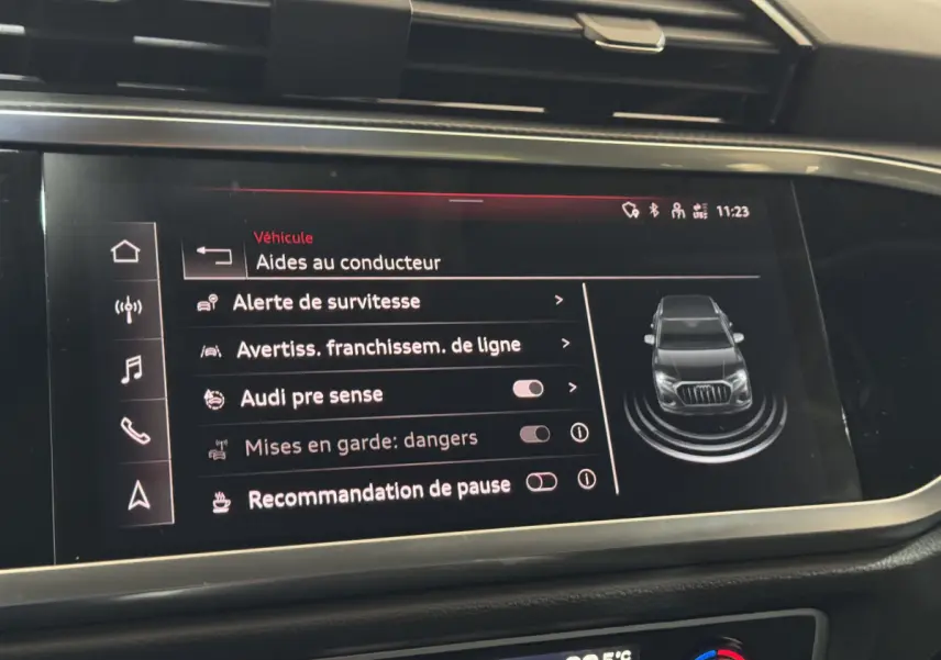 Écran tactile intérieur de l'Audi Q3 noir 2022 affichant les aides au conducteur et options de sécurité.