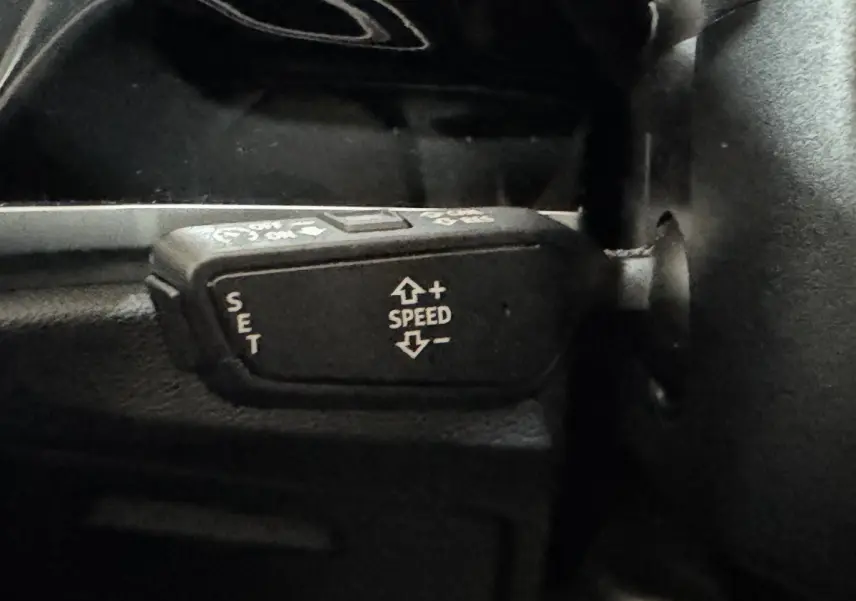 Gros plan sur la commande de régulateur de vitesse du volant noir de l'Audi Q3 35 TFSI 2022.