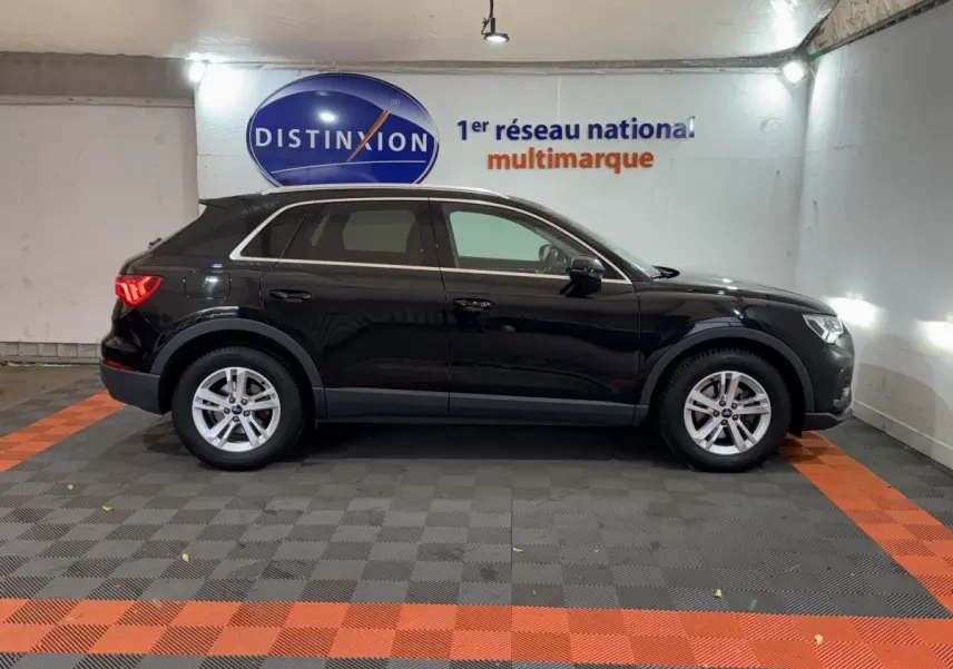 Audi Q3 noir vue de profil côté gauche dans un garage avec logo Distinxion en arrière-plan.