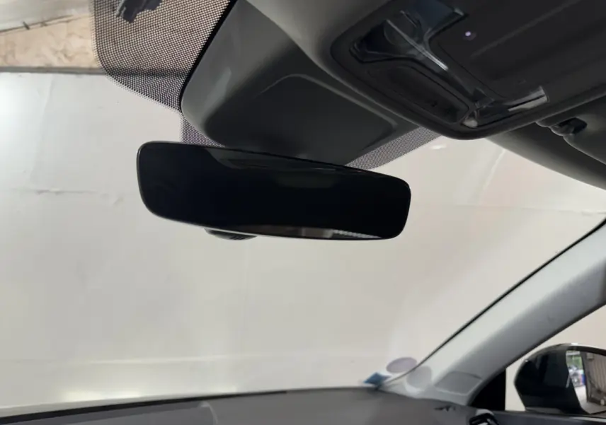 Rétroviseur intérieur noir vu de dessous dans l'Audi Q3 35 TFSI 2022, avec toit clair et pare-brise visible.