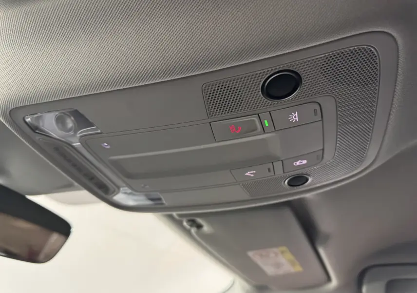 Vue en gros plan du plafonnier gris avec commandes d'éclairage et assistance dans l'Audi Q3 noir 2022.