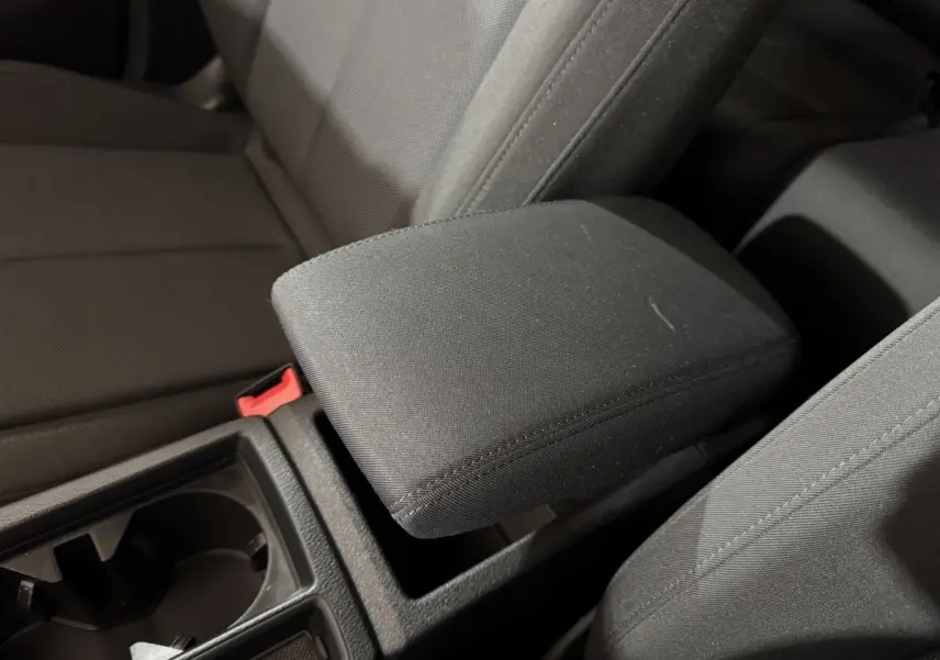 Gros plan sur l'accoudoir central noir et les sièges tissu foncé de l'Audi Q3 35 TFSI 2022.