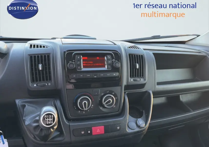 Vue intérieure du tableau de bord de l'Opel Movano Fourgon blanc, avec console centrale et levier de vitesse manuel visible.