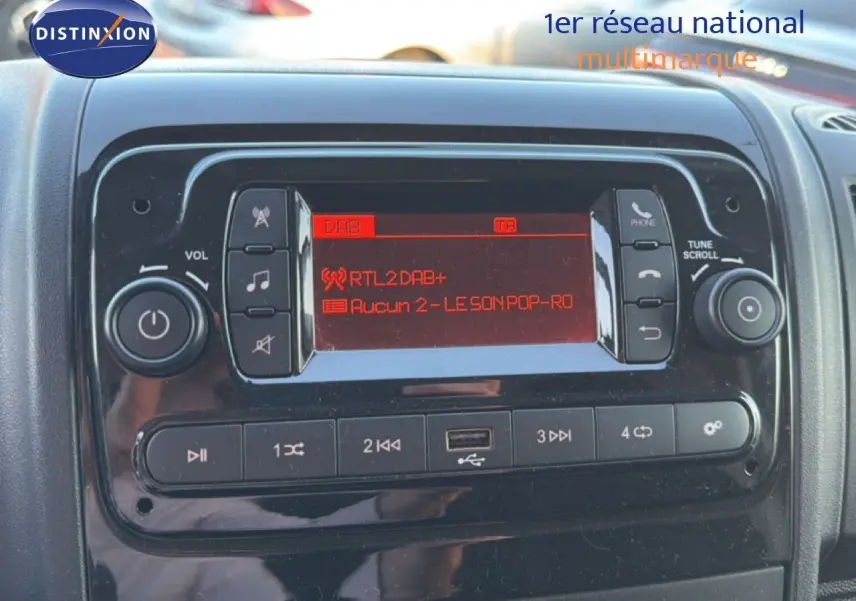 Détail du tableau de bord de l'Opel Movano Fourgon 2023 montrant l'autoradio avec écran rouge et commandes intégrées.