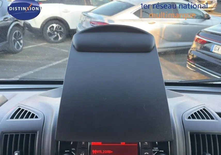 Vue intérieure centrée sur la console centrale noire du fourgon Opel Movano blanc, avec aérateurs visibles de chaque côté.