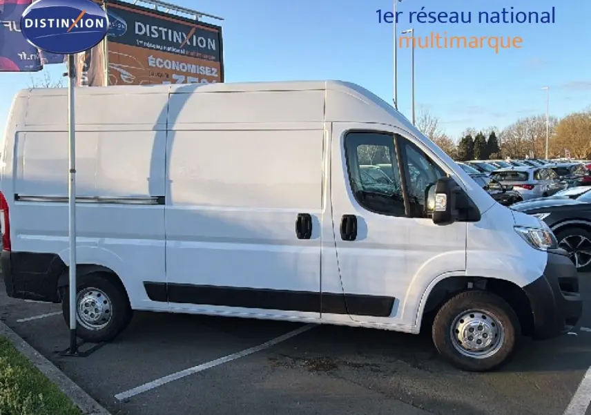 Opel Movano Fourgon blanc icy vu de profil côté droit, stationné sur un parking extérieur en journée.