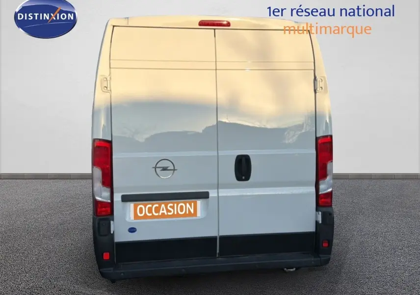 Vue arrière d’un fourgon Opel Movano blanc Icy, version L2H2, avec portes battantes fermées et logo Opel visible.
