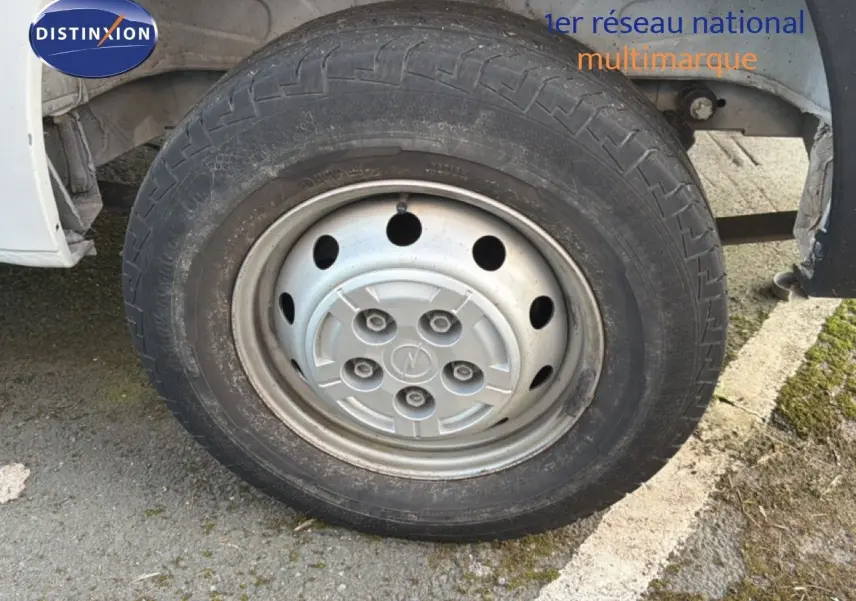 Gros plan sur la roue avant droite du fourgon blanc Opel Movano L2H2 2023 avec jante acier et logo Opel central.