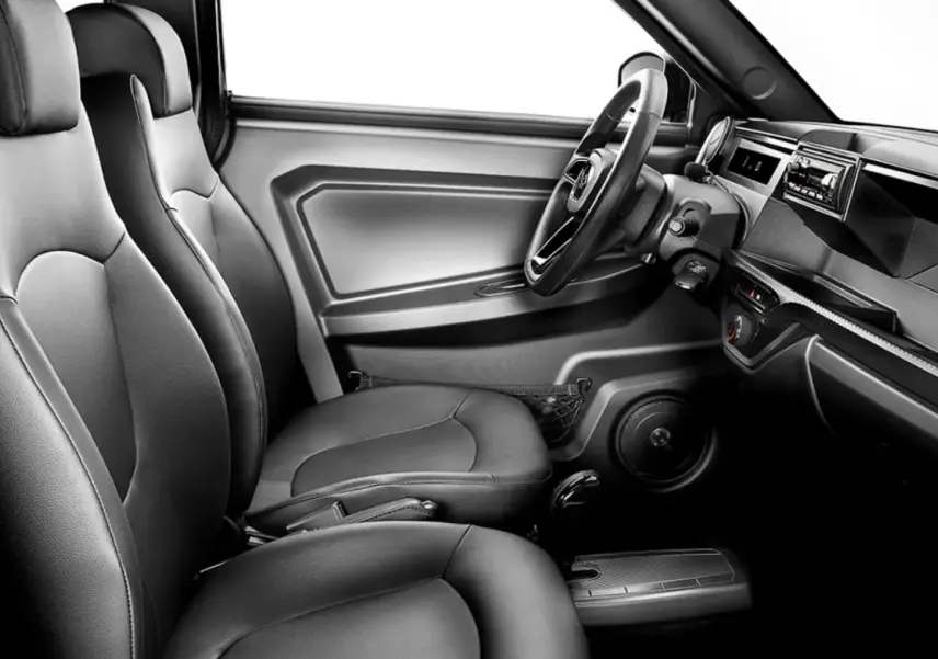 Vue intérieure côté conducteur de la LIGIER Myli 0.5 REVO D+ 2026, sièges simili-cuir noirs et tableau de bord moderne.