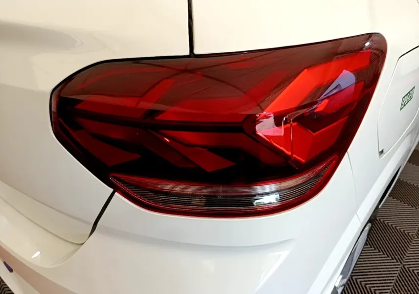 Gros plan sur le feu arrière droit rouge d’une Dacia Sandero Confort TCe 90 blanche, vue arrière côté droit.