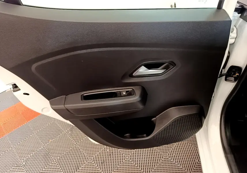 Vue rapprochée de la porte avant droite noire avec poignée argentée et bouton de verrouillage sur Dacia Sandero blanc 2022.