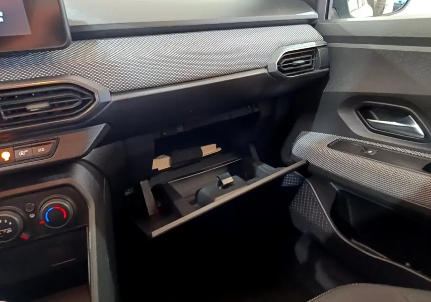 Intérieur de la Dacia Sandero Confort TCe 90 2022, vue côté passager avec boîte à gants ouverte et détails de la planche de bord.