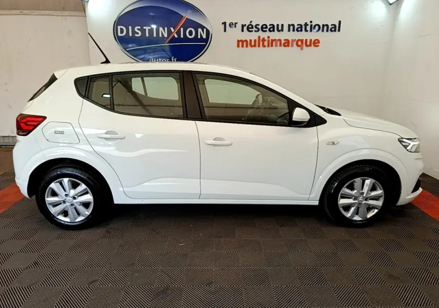 Profil côté gauche d'une Dacia Sandero Confort TCe 90 blanche 2022, avec jantes alliage et feux arrière visibles.
