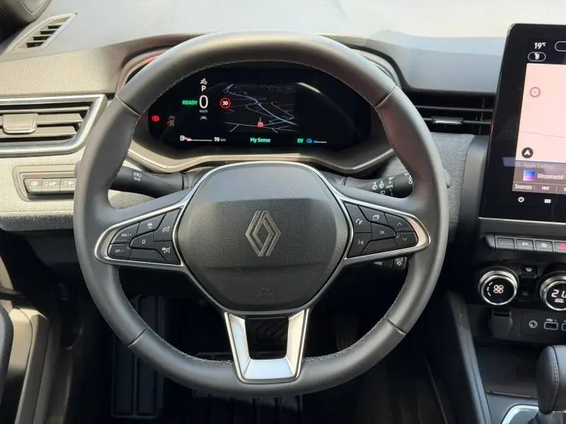 Vue rapprochée du volant et du tableau de bord numérique de la Renault Clio 1.6 E-Tech 145ch hybride, intérieur noir moderne.