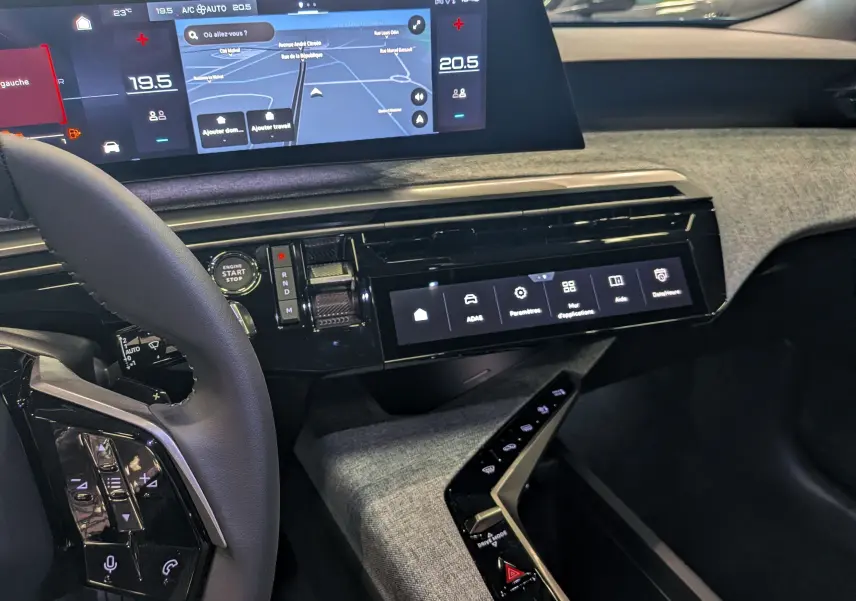 Intérieur du Peugeot 3008 Hybrid 2026 vu côté conducteur, tableau de bord avec écran tactile et finition tissu gris.