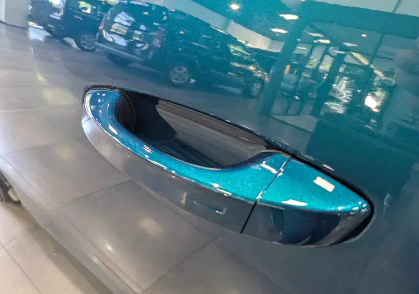 Poignée de porte côté gauche bleu Obsession du Peugeot 3008 Hybrid 145 CH e-DCS6 Allure, finition brillante et lisse.