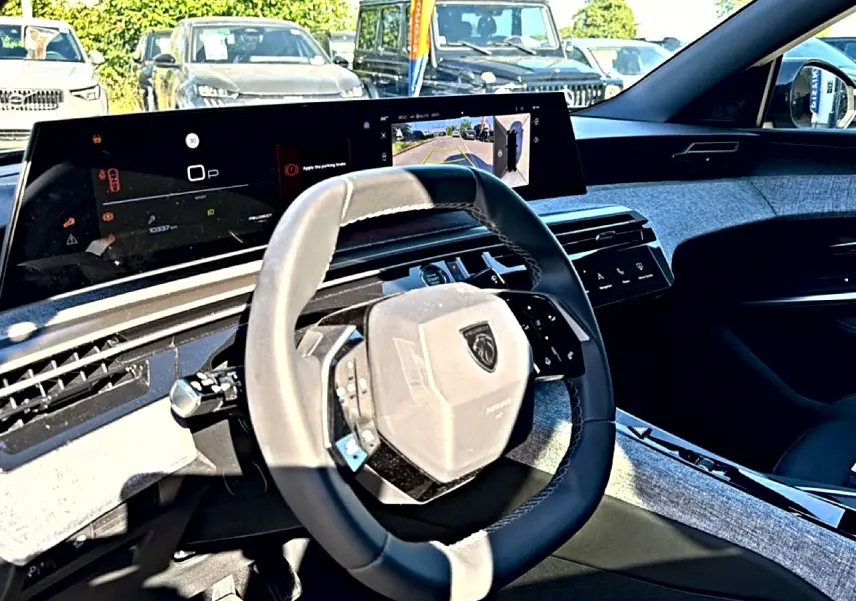 Vue intérieure côté conducteur du Peugeot 3008 2025 avec volant cuir et écran tactile panoramique.