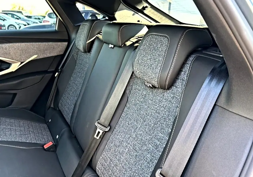 Vue rapprochée de la banquette arrière en tissu gris et cuir noir du Peugeot 3008 1.2 hybrid 145 allure 2025.