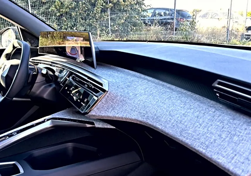 Vue intérieure côté passager du tableau de bord du Peugeot 3008 1.2 hybrid 145 allure e-dcs6 avec écran tactile et finition tissu gris.