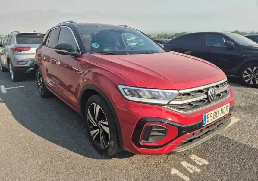 Volkswagen T-Roc rouge métal foncé vue 3/4 avant droit avec toit noir et jantes alliage.