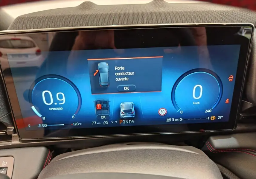 Affichage numérique du combiné d'instruments du Ford Puma bleu 2025, indiquant porte conducteur ouverte et vitesse à 0 km/h.