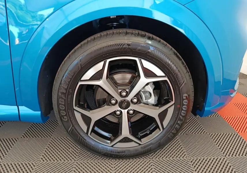 Gros plan sur la roue avant droite bleue du Ford Puma 2025 avec jante alliage et pneu Goodyear visible