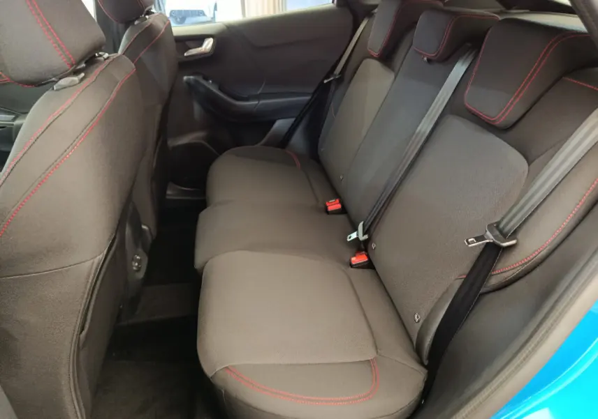 Vue côté droit de la banquette arrière noire avec surpiqûres rouges du Ford Puma bleu 2025 ST-LINE hybride.