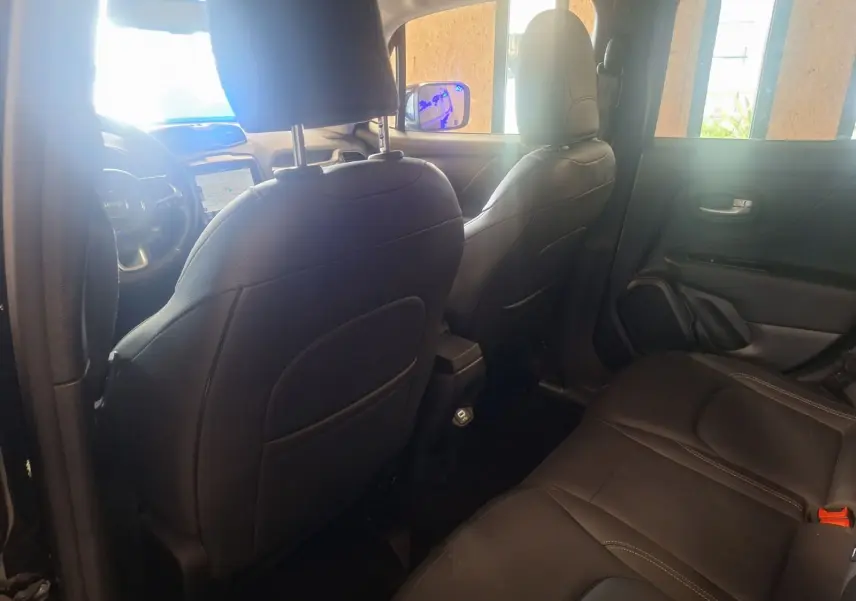 Vue intérieure arrière du Jeep Renegade 2024 noir, mettant en valeur les sièges en cuir noir et la console centrale.