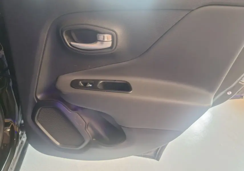 Gros plan sur la porte arrière droite noire d'un Jeep Renegade 2024 avec poignée et haut-parleur intégrés.