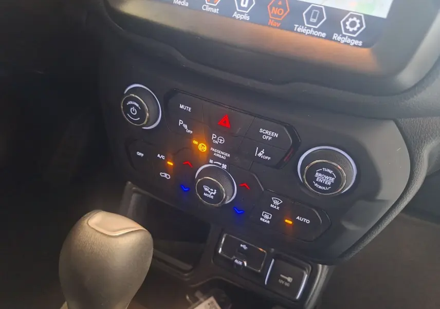 Vue rapprochée de la console centrale du Jeep Renegade noir 2024, montrant les commandes climatisation et le levier de vitesse automatique.