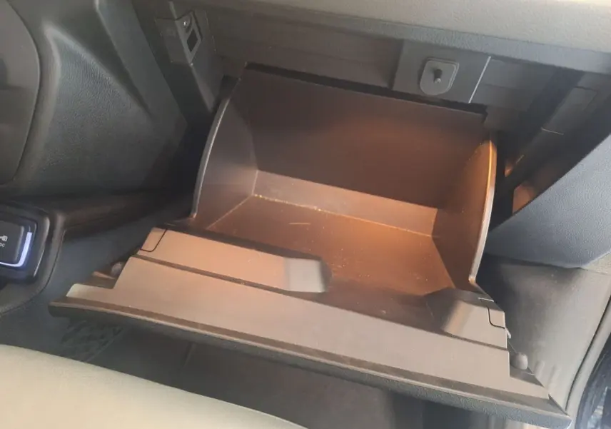 Gant de rangement ouvert côté passager du Jeep Renegade noir 2024, intérieur sombre avec éclairage intérieur doux.