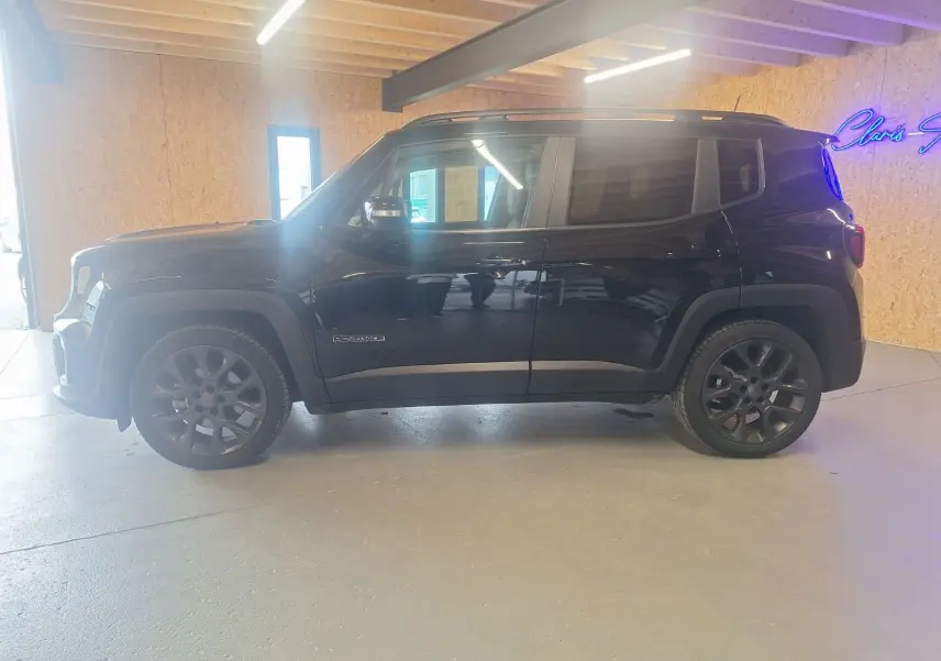 Jeep Renegade noir en vue profil côté gauche, avec jantes foncées et intérieur visible à travers les vitres.
